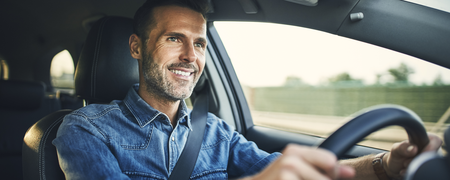 Man in blue shirt driving happily